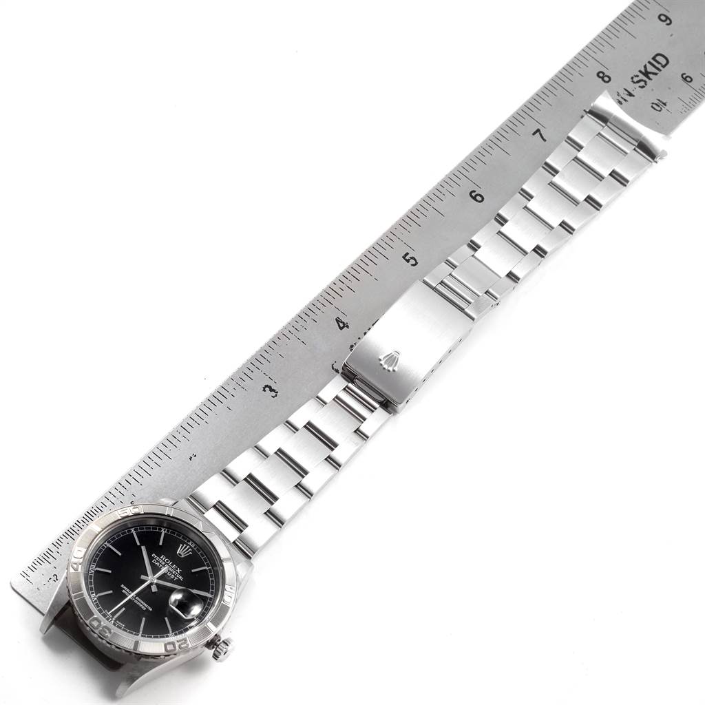 The Rolex Turn-o-Graph 16264 Men
s Stainless Steel Black Dial 16264 Men
s Stainless Steel Black Dial watch is shown with its band extended, placed next to a ruler for measurement.