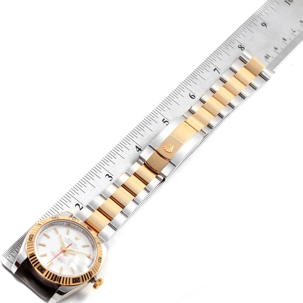 The Rolex Turn-o-Graph 116263 Men
s Steel and Gold (two tone) White Dial 116263 Men
s Steel and Gold (two tone) White Dial watch is shown from a top-down angle, highlighting its gold and steel bracelet alongside a ruler for scale.