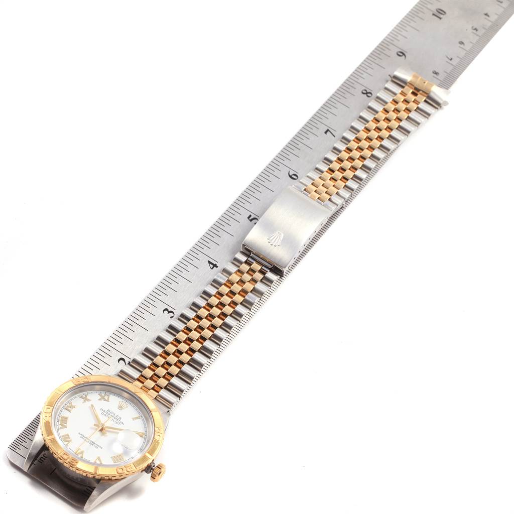 The Rolex Turn-o-Graph 16263 Men
s Steel and Gold (two tone) White Dial 16263 Men
s Steel and Gold (two tone) White Dial watch is shown laid flat alongside a ruler, highlighting the face and full bracelet.