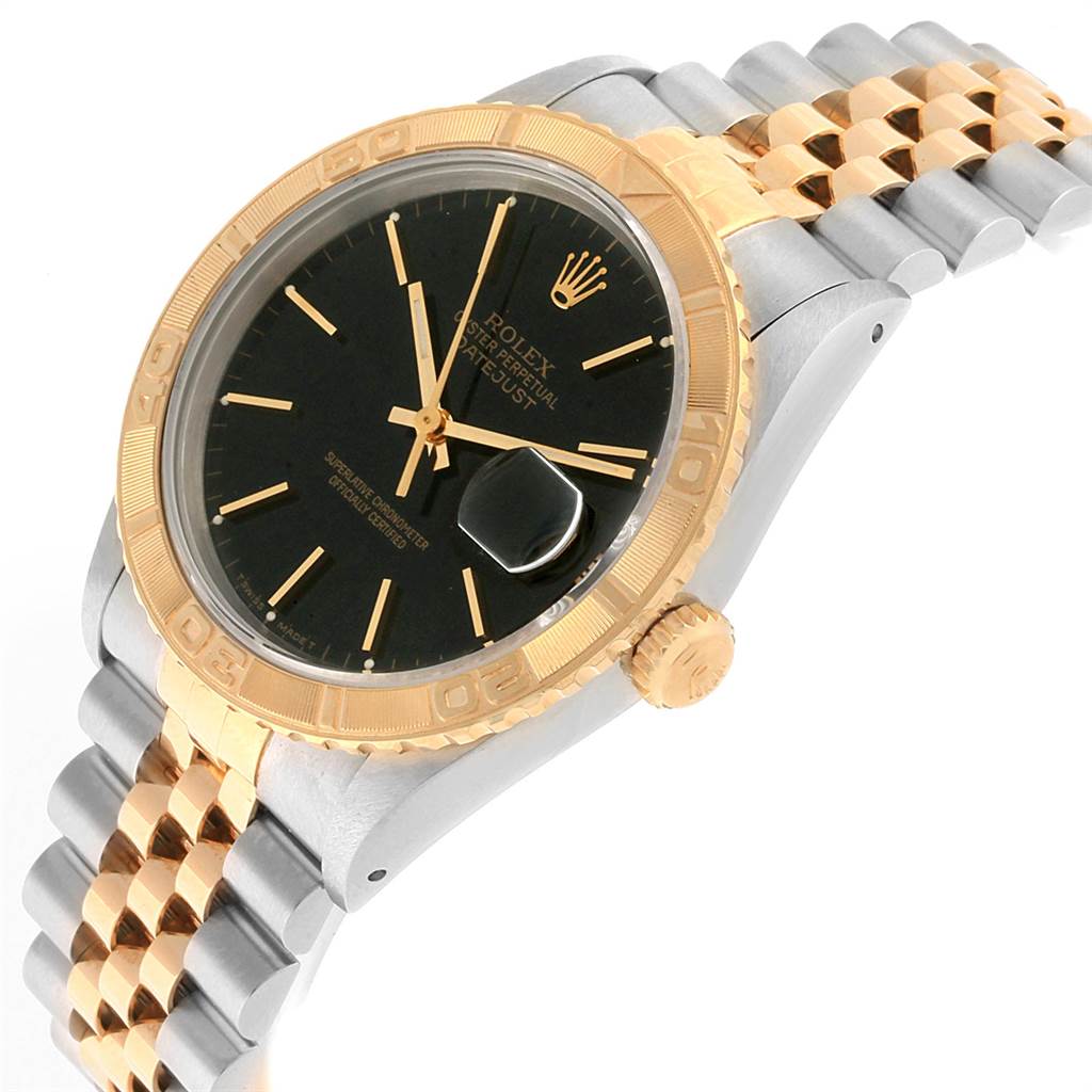 The image shows a Rolex Turn-o-Graph 16263 Men
s Steel and Gold (two tone) Black Dial 16263 Men
s Steel and Gold (two tone) Black Dial watch at an oblique angle, featuring its black dial, gold bezel, and two-tone Jubilee bracelet.