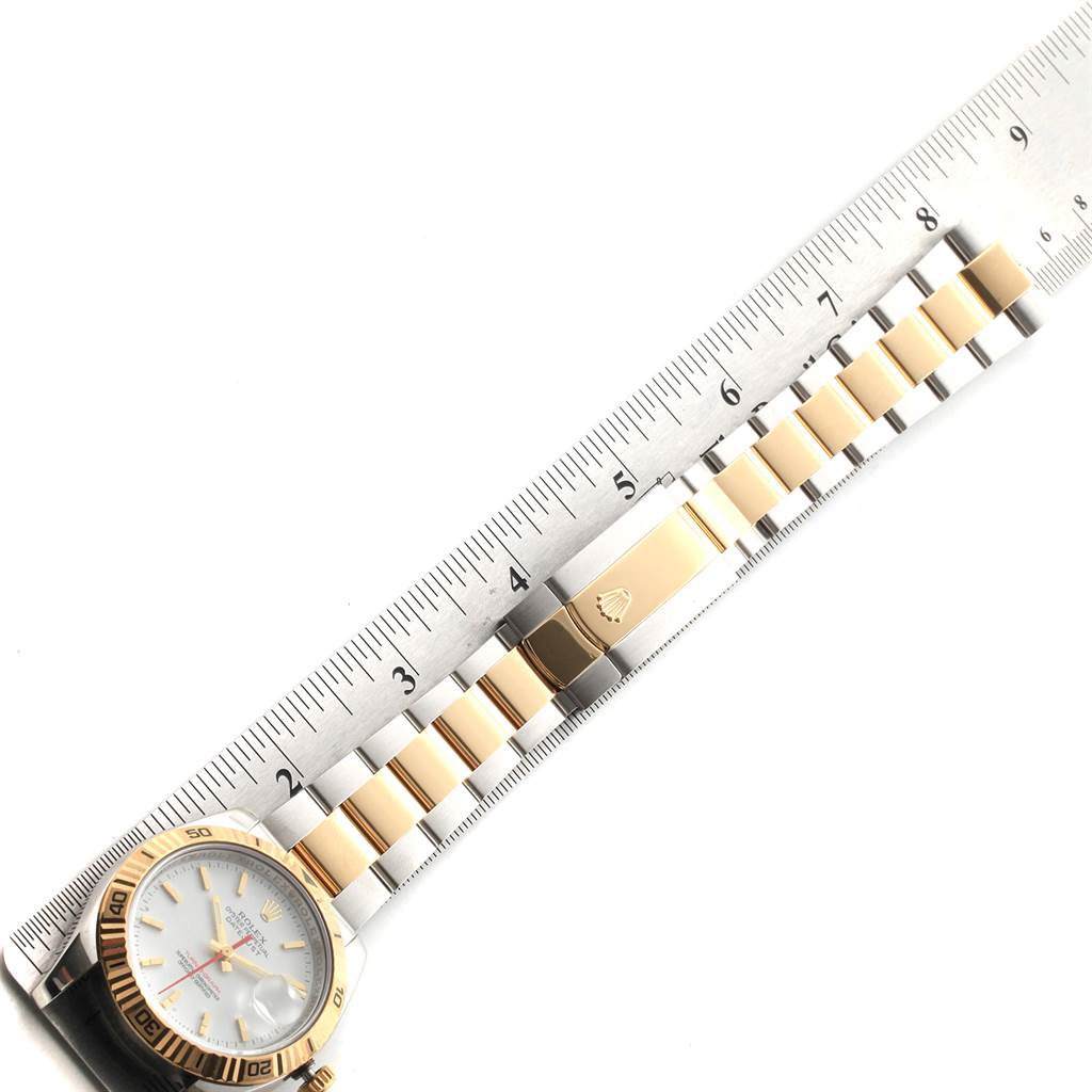 This image displays the Rolex Turn-o-Graph 116263 Men
s Stainless Steel White Dial 116263 Men
s Stainless Steel White Dial watch from an overhead angle, focusing on its face, bezel, and bracelet alongside a ruler.