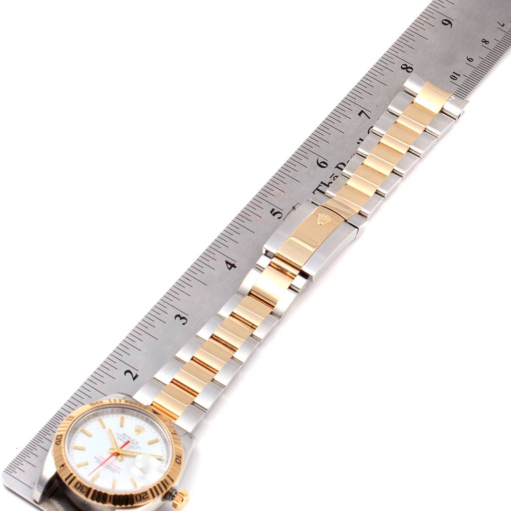 The Rolex Turn-o-Graph 116263 Men's Steel and Gold (two tone) White Dial 116263 Men's Steel and Gold (two tone) White Dial watch is shown from a top-down angle, displaying the face, bracelet, and clasp alongside a ruler for measurement.