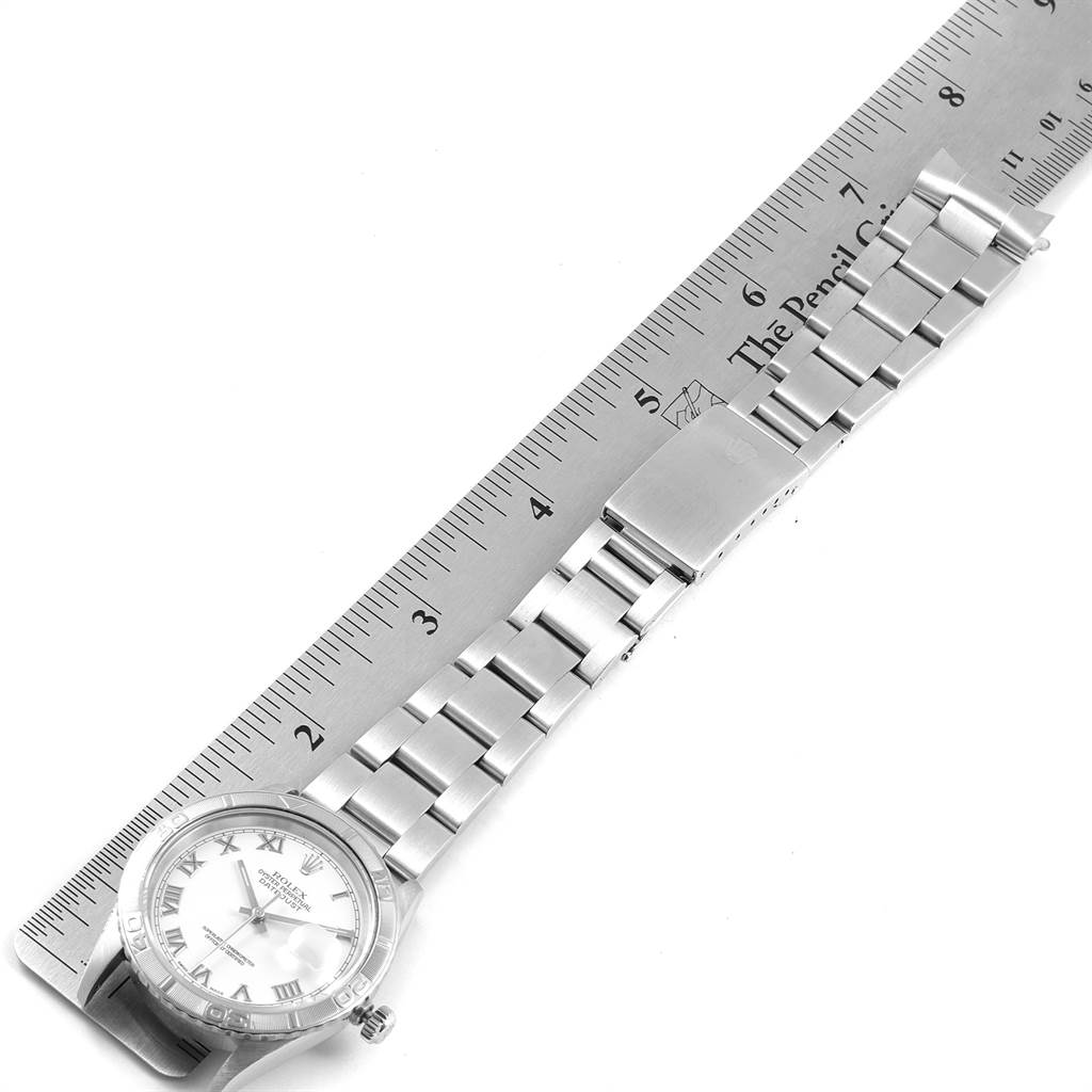 The image shows a top-down view of a Rolex Turn-o-Graph 16264 Men
s Stainless Steel White Dial 16264 Men
s Stainless Steel White Dial watch, displaying its bracelet, clasp, and part of the dial alongside a ruler for scale.