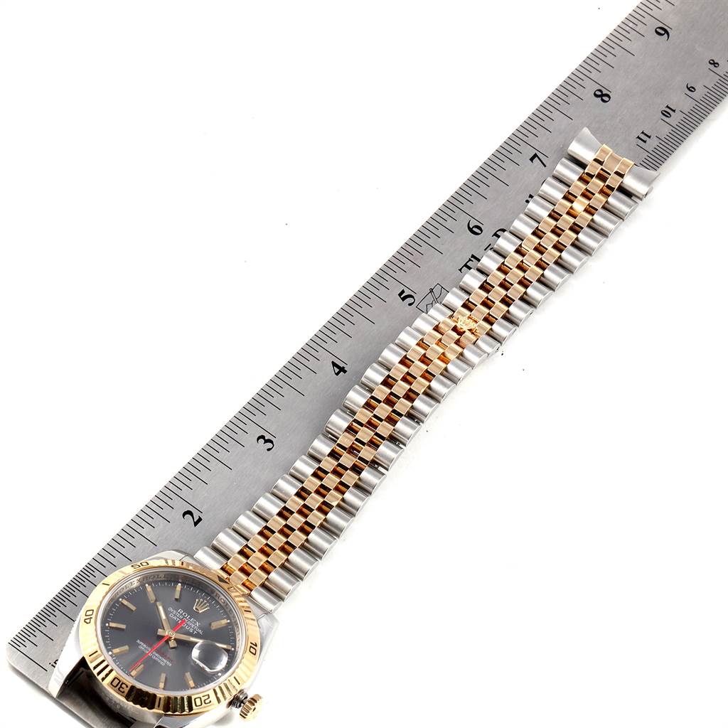 The image shows a Rolex Turn-o-Graph 116263 Men
s Steel and Gold (two tone) Grey Dial 116263 Men
s Steel and Gold (two tone) Grey Dial watch laid flat alongside a ruler, highlighting its band and dial.