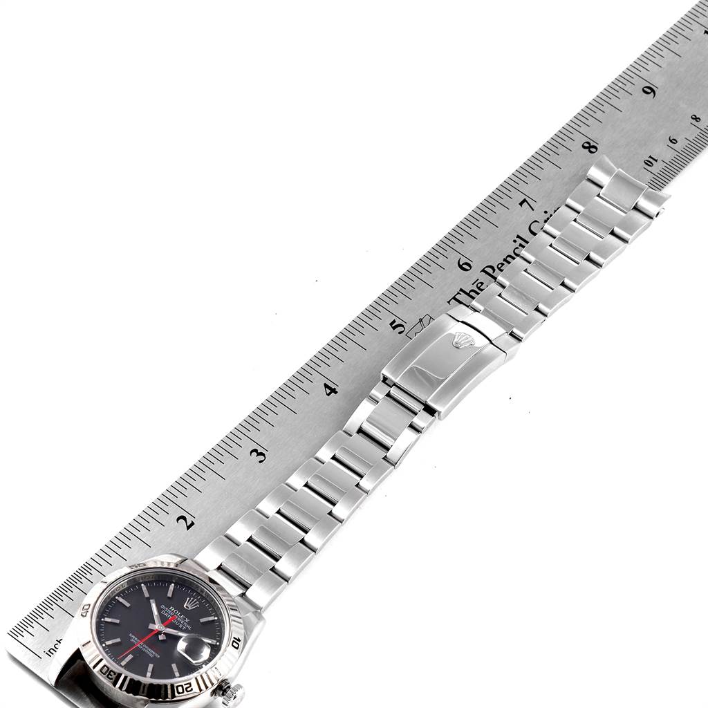 This image shows a Rolex Turn-o-Graph 116264 Men
s Stainless Steel Black Dial 116264 Men
s Stainless Steel Black Dial watch laid flat with its band extended next to a ruler for measurement.