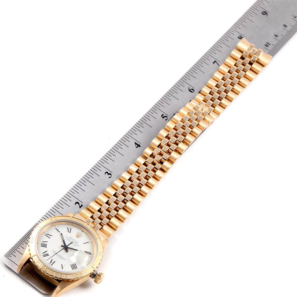 The Rolex Turn-o-Graph 16258 Men
s Yellow Gold White Dial 16258 Men
s Yellow Gold White Dial watch is displayed horizontally, showing the face, bezel, and band next to a ruler for measurement.