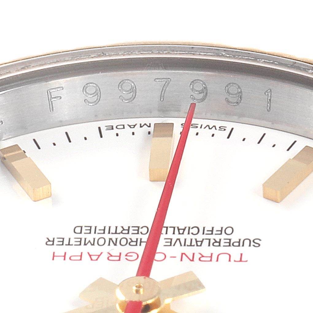 This image of the Rolex Turn-o-Graph 116263 Men
s Stainless Steel White Dial 116263 Men
s Stainless Steel White Dial watch shows the dial, red second hand, hour indices, and a portion of the inner bezel with serial markings.