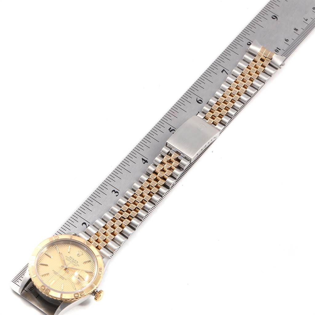 The image shows a Rolex Turn-o-Graph 16263 Men
s Steel and Gold (two tone) Champagne Dial 16263 Men
s Steel and Gold (two tone) Champagne Dial watch laid flat with a stainless steel and gold jubilee bracelet and clasp, positioned next to a ruler for measurement.