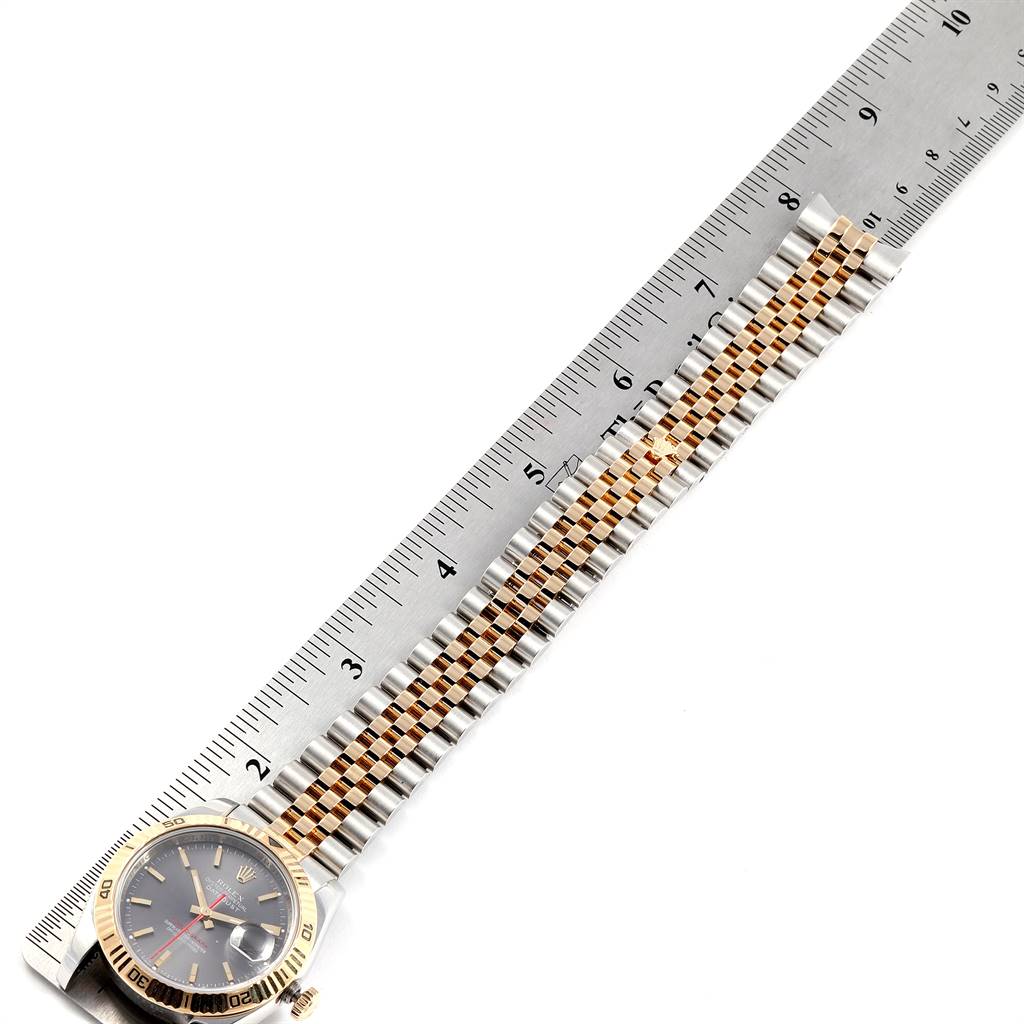 This image shows the Rolex Turn-o-Graph 116263 Men
s Steel and Gold (two tone) Grey Dial 116263 Men
s Steel and Gold (two tone) Grey Dial watch in a horizontal position, fully extended with a metal ruler beside it for measurement.