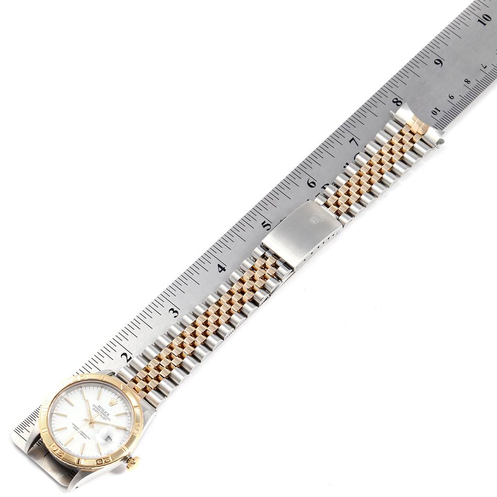 The image shows a Rolex Turn-o-Graph 16263 Men's Steel and Gold (two tone) White Dial 16263 Men's Steel and Gold (two tone) White Dial watch laid flat next to a ruler, highlighting the band and face.