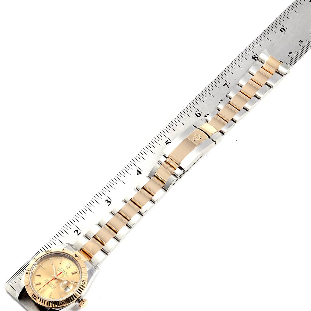 The image shows a Rolex Turn-o-Graph 116263 Men
s Steel and Gold (two tone) Champagne Dial 116263 Men
s Steel and Gold (two tone) Champagne Dial watch horizontally aligned against a ruler, displaying the watch face and bracelet.