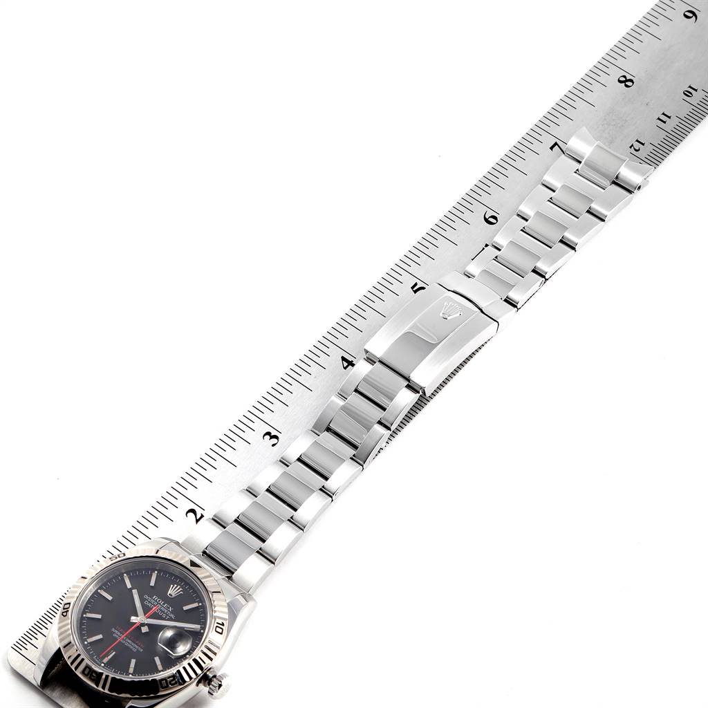 The image shows a Rolex Turn-o-Graph 116264 Men
s Stainless Steel Black Dial 116264 Men
s Stainless Steel Black Dial watch laid flat next to a ruler, displaying the face, bezel, and bracelet.