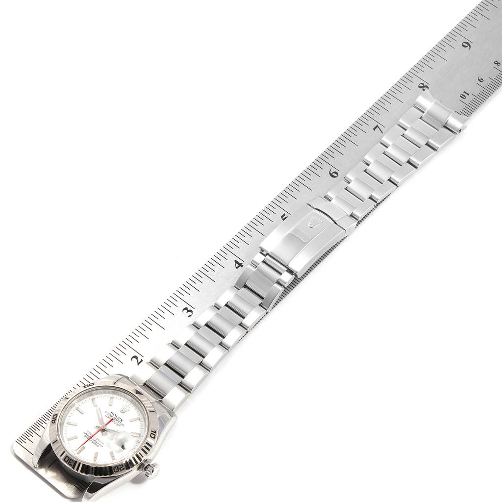 The Rolex Turn-o-Graph 116264 Men
s Stainless Steel White Dial 116264 Men
s Stainless Steel White Dial watch is shown from an overhead angle with its bracelet laid out and measured against a ruler.