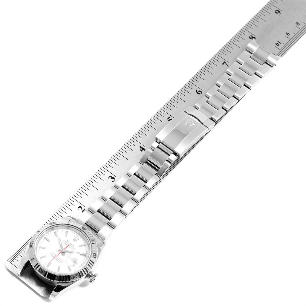 The image shows a top view of a Rolex Turn-o-Graph 116264 Men's Stainless Steel White Dial 116264 Men's Stainless Steel White Dial watch laid diagonally across a ruler, highlighting its dial, bezel, and bracelet.