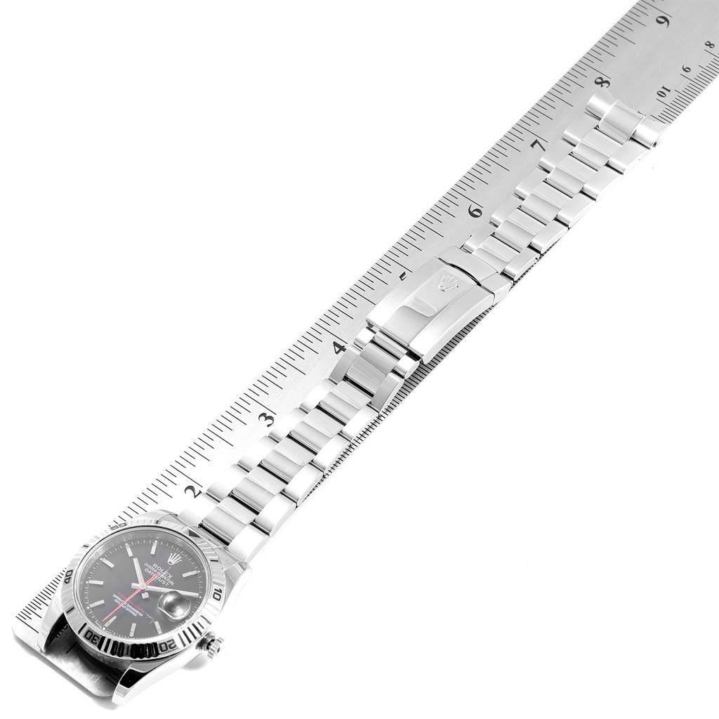 This image shows a Rolex Turn-o-Graph 116264 Men
s Stainless Steel Black Dial 116264 Men
s Stainless Steel Black Dial watch in a top-down view, highlighting its face, bezel, bracelet, and clasp alongside a ruler.