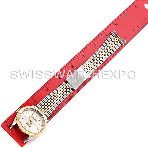 This image shows a top-down view of a Rolex Turn-o-Graph 16263 Men's Steel and Gold (two tone) Silver Dial 16263 Men's Steel and Gold (two tone) Silver Dial watch, displaying its face, bezel, band, and clasp next to a red ruler.