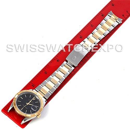 This image shows a Rolex Turn-o-Graph 16263 Men's Steel and Gold (two tone) Black Dial 16263 Men's Steel and Gold (two tone) Black Dial watch with a two-tone bracelet and a black dial, lying flat against a red ruler from a top-down angle.