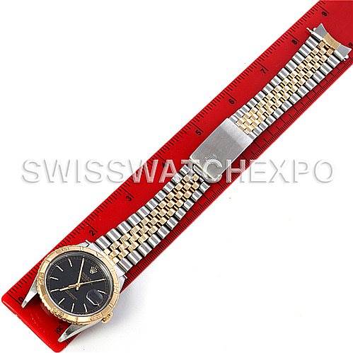 The image shows a Rolex Turn-o-Graph 16263 Men's Steel and Gold (two tone) Black Dial 16263 Men's Steel and Gold (two tone) Black Dial watch placed along a red ruler, highlighting its bracelet and clasp.