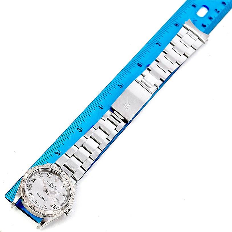 The Rolex Turn-o-Graph 16264 Men's Stainless Steel Silver Dial 16264 Men's Stainless Steel Silver Dial watch is shown in full length laid flat next to a ruler, displaying its face, bracelet, and clasp.