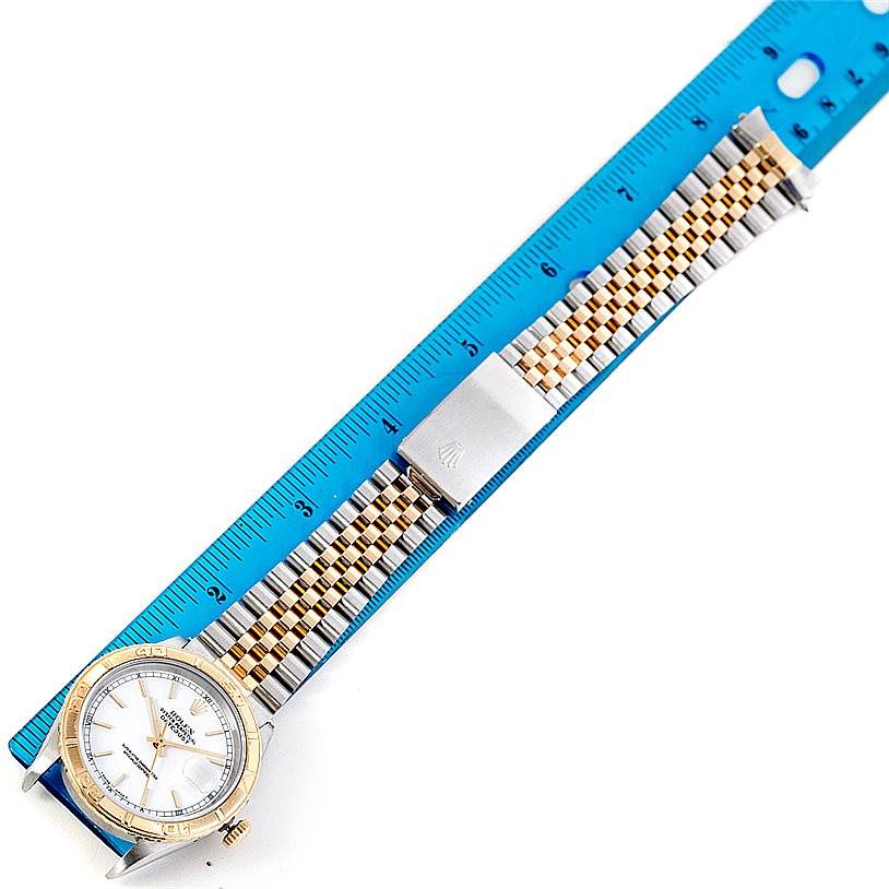 The Rolex Turn-o-Graph 16263 Men's Steel and Gold (two tone) White Dial 16263 Men's Steel and Gold (two tone) White Dial watch is shown from a top angle, highlighting the watch face, bezel, and bracelet against a ruler for scale.