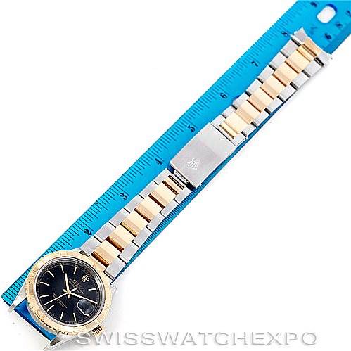 The Rolex Turn-o-Graph 16263 Men's Steel and Gold (two tone) Black Dial 16263 Men's Steel and Gold (two tone) Black Dial watch is displayed flat, showing the face, bezel, and entire band against a blue ruler for measurements.