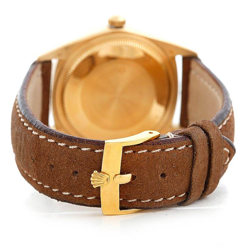 The image shows the back view of a Rolex Turn-o-Graph 1625 Men's Yellow Gold Champagne Dial 1625 Men's Yellow Gold Champagne Dial watch, highlighting its brown leather strap with a gold buckle.