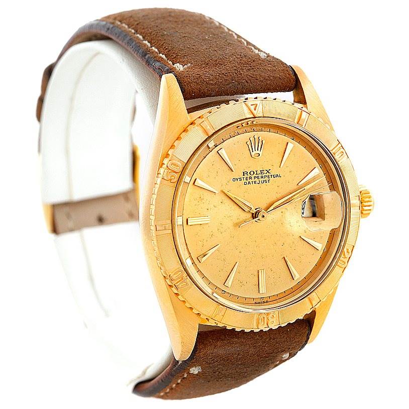 The Rolex Turn-o-Graph 1625 Men's Yellow Gold Champagne Dial 1625 Men's Yellow Gold Champagne Dial watch is shown at a slight angle, displaying the dial, bezel, and leather strap.