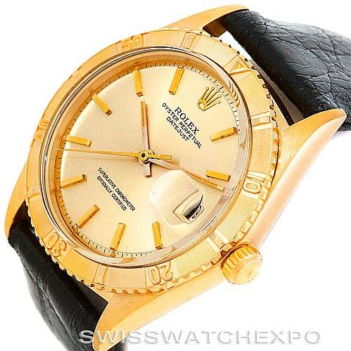This image shows a Rolex Turn-o-Graph 1625 Men's Yellow Gold Champagne Dial 1625 Men's Yellow Gold Champagne Dial watch from an oblique angle, highlighting the face, bezel, and leather strap.