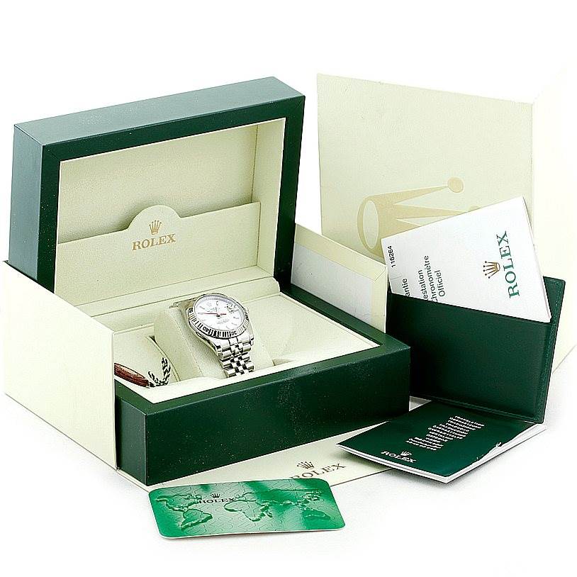 The Turn-o-Graph model by Rolex is shown in its open box, along with associated booklets and a green card.