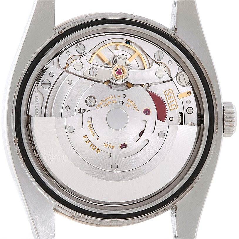 The image shows the internal mechanism of a Rolex Turn-o-Graph 116264 Men's Stainless Steel White Dial 116264 Men's Stainless Steel White Dial watch from a rear angle, featuring gears and the rotor.