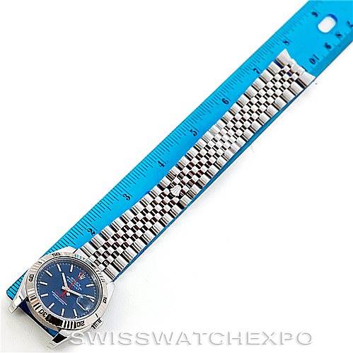 The Rolex Turn-o-Graph 116264 Men's Stainless Steel Blue Dial 116264 Men's Stainless Steel Blue Dial watch is shown from a top-down angle, highlighting its face, bezel, and bracelet next to a blue ruler.