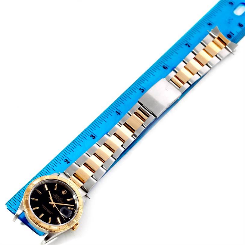 The image shows a Rolex Turn-o-Graph 16263 Men's Steel and Gold (two tone) Black Dial 16263 Men's Steel and Gold (two tone) Black Dial watch laid flat against a blue ruler, fully displaying its two-tone bracelet and face.