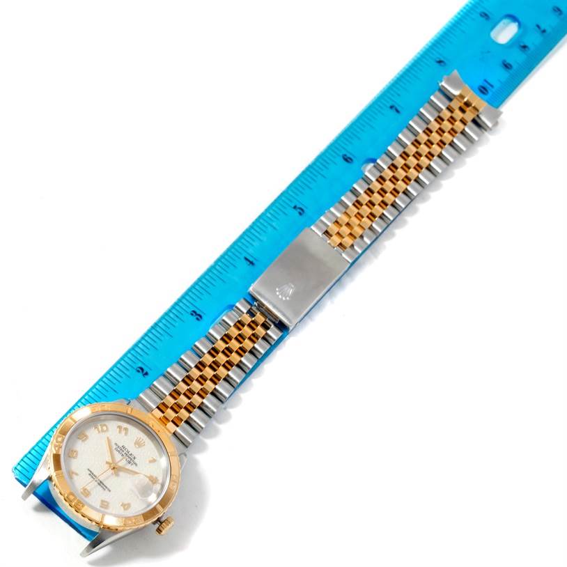 This image shows a top-down view of a Rolex Turn-o-Graph 16263 Men's Steel and Gold (two tone) Beige Dial 16263 Men's Steel and Gold (two tone) Beige Dial model watch, including its face, bezel, and bracelet alongside a ruler for scale.