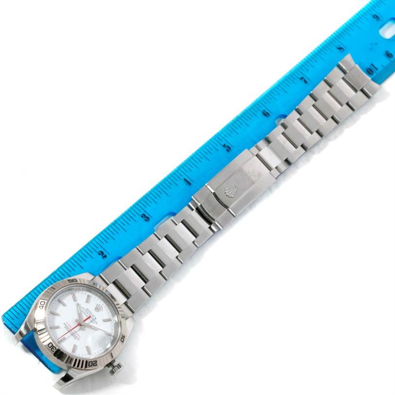 The image shows a Rolex Turn-o-Graph 116264 Men
s Stainless Steel White Dial 116264 Men
s Stainless Steel White Dial watch laid flat next to a blue ruler, displaying the watch face and bracelet.