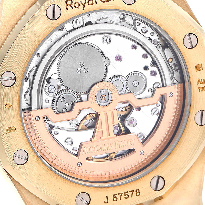 The image shows the back of the Audemars Piguet Royal Oak watch, highlighting its visible mechanical movement and rotor.