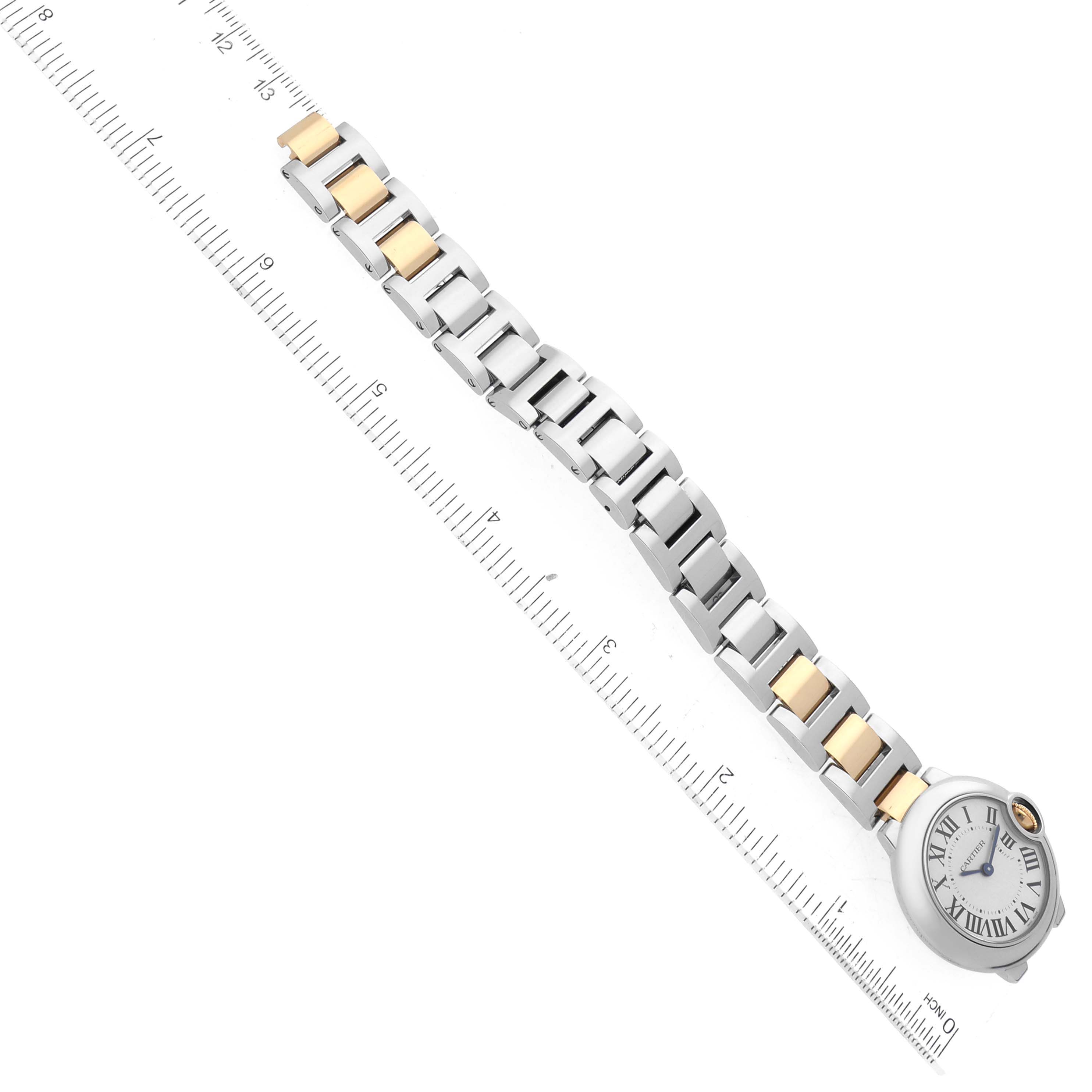 The image shows a Cartier Ballon Bleu W69007Z3 Women
s Steel and Gold (two tone) Silver Dial W69007Z3 Women
s Steel and Gold (two tone) Silver Dial watch laid flat alongside a ruler, highlighting its bracelet and face.