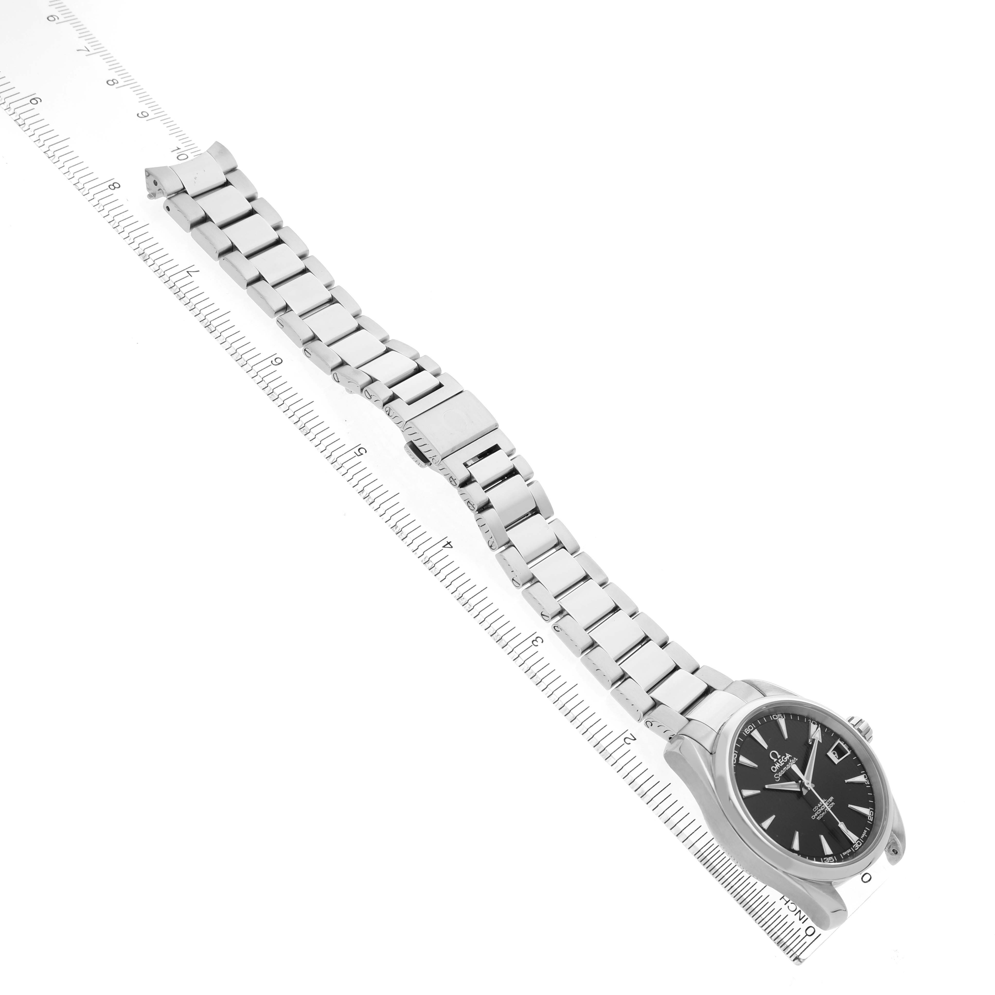 The Omega Seamaster 231.10.39.21.01.001 Men's Stainless Steel Black Dial watch is shown at an angle displaying the entire metal bracelet and face, next to a ruler for scale.