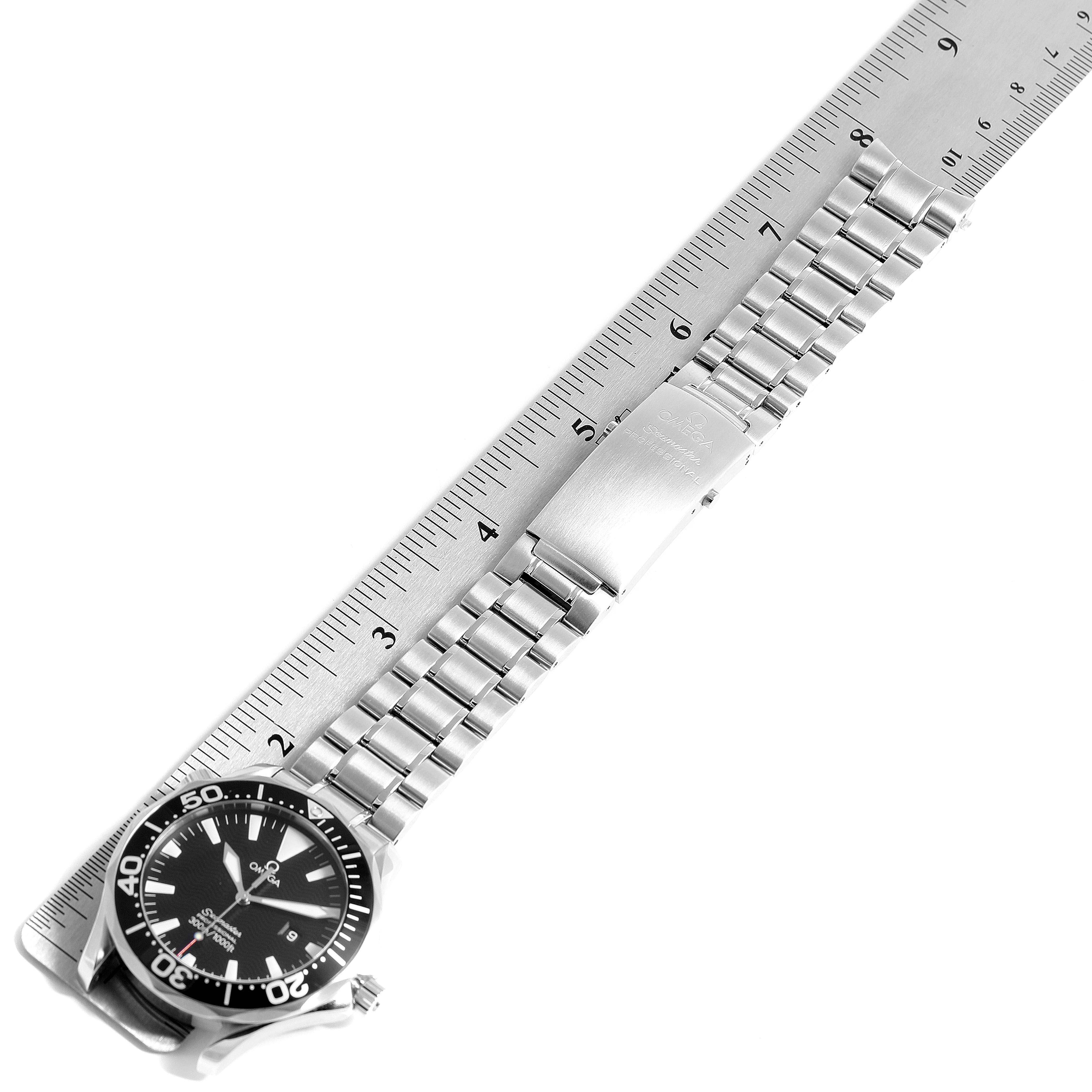 The Omega Seamaster 2264.50.00 Men
s Stainless Steel Black Dial 2264.50.00 Men
s Stainless Steel Black Dial watch is shown flat against a ruler, displaying its face, bezel, bracelet, and clasp.