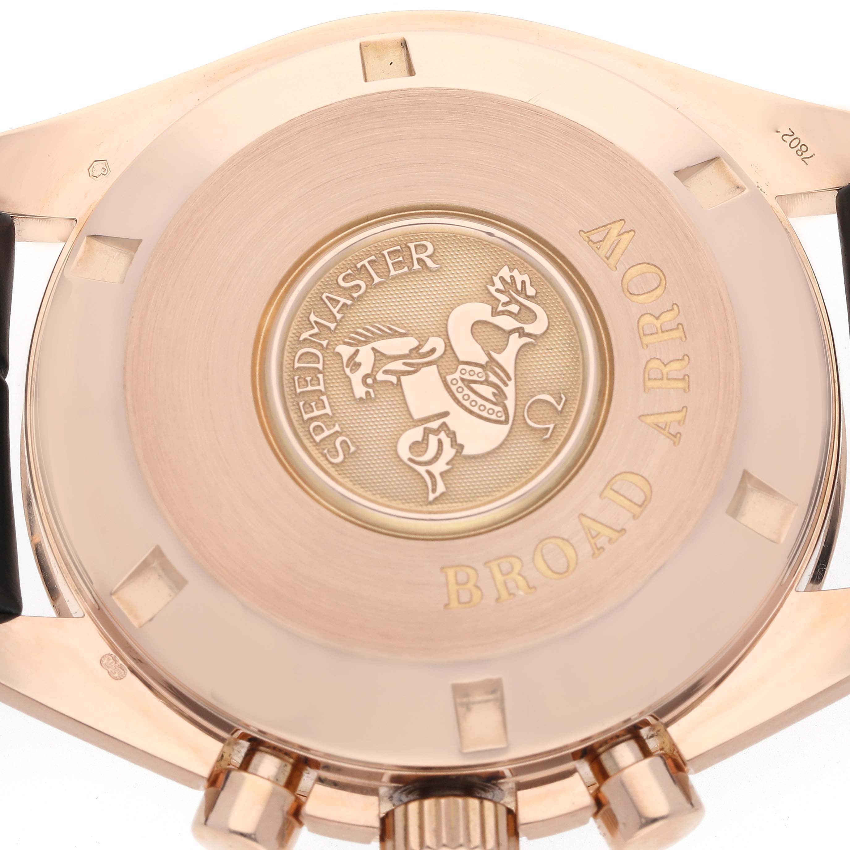 The image shows the case back and crown of the Omega Speedmaster 3653.80.33 Men's Rose Gold Blue Dial 3653.80.33 Men's Rose Gold Blue Dial Broad Arrow watch from a straight-on angle.