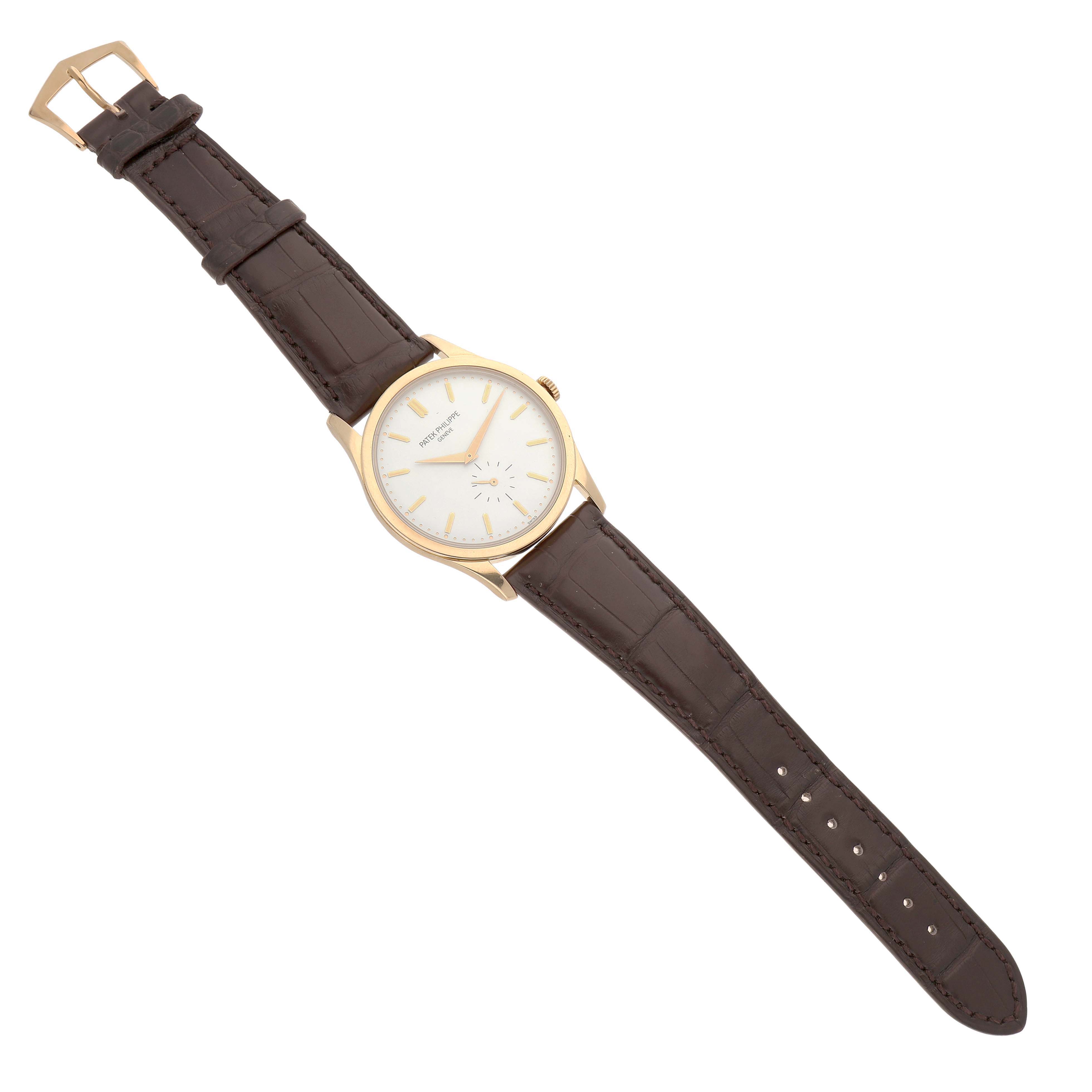 The Patek Philippe Calatrava 5196J Men's Yellow Gold Silver Dial watch is shown from a top-down angle, displaying the face, strap, and buckle.