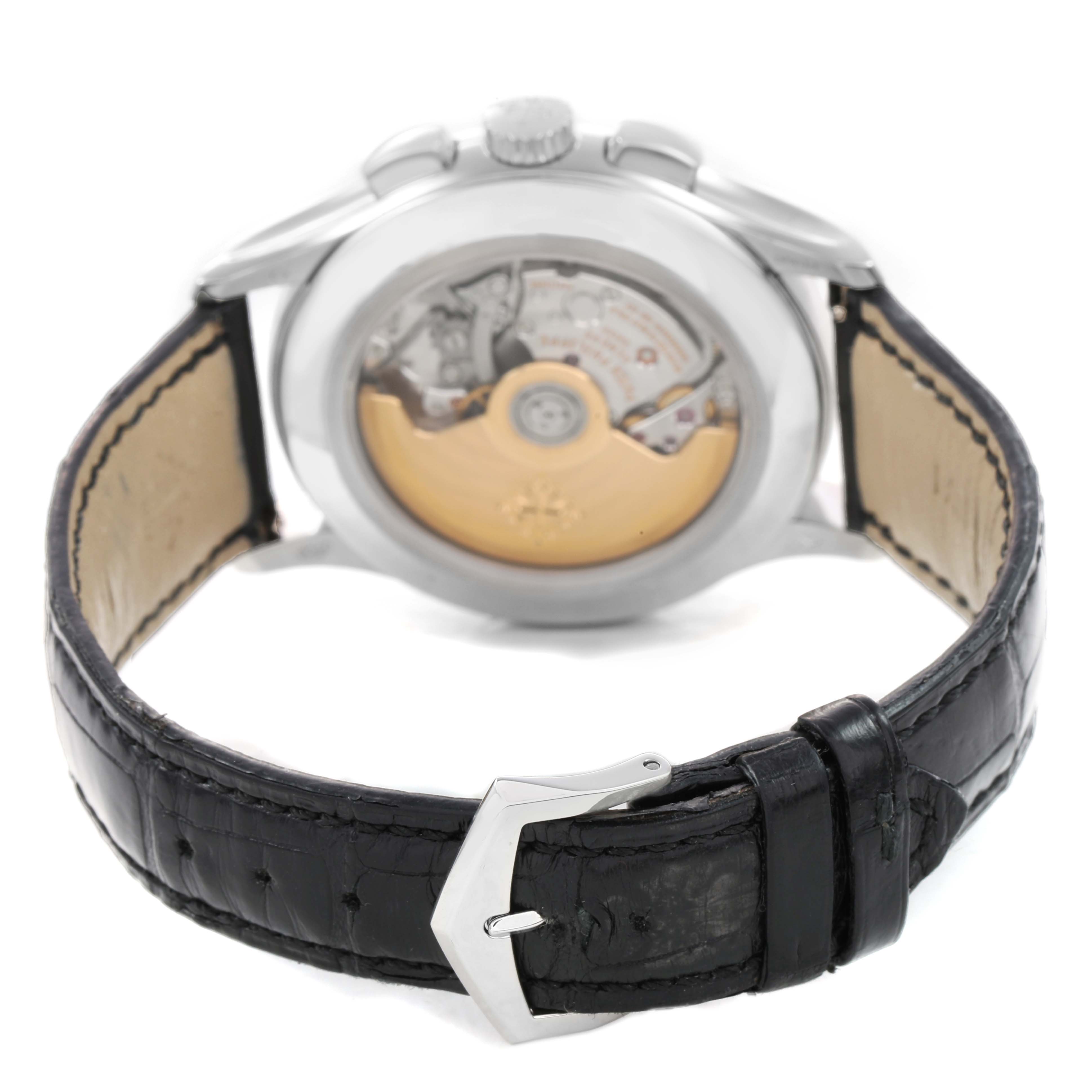 The Patek Philippe Complications 5905 Men's Platinum Black Dial watch is shown from the back, highlighting the movement through a transparent case back and leather strap.