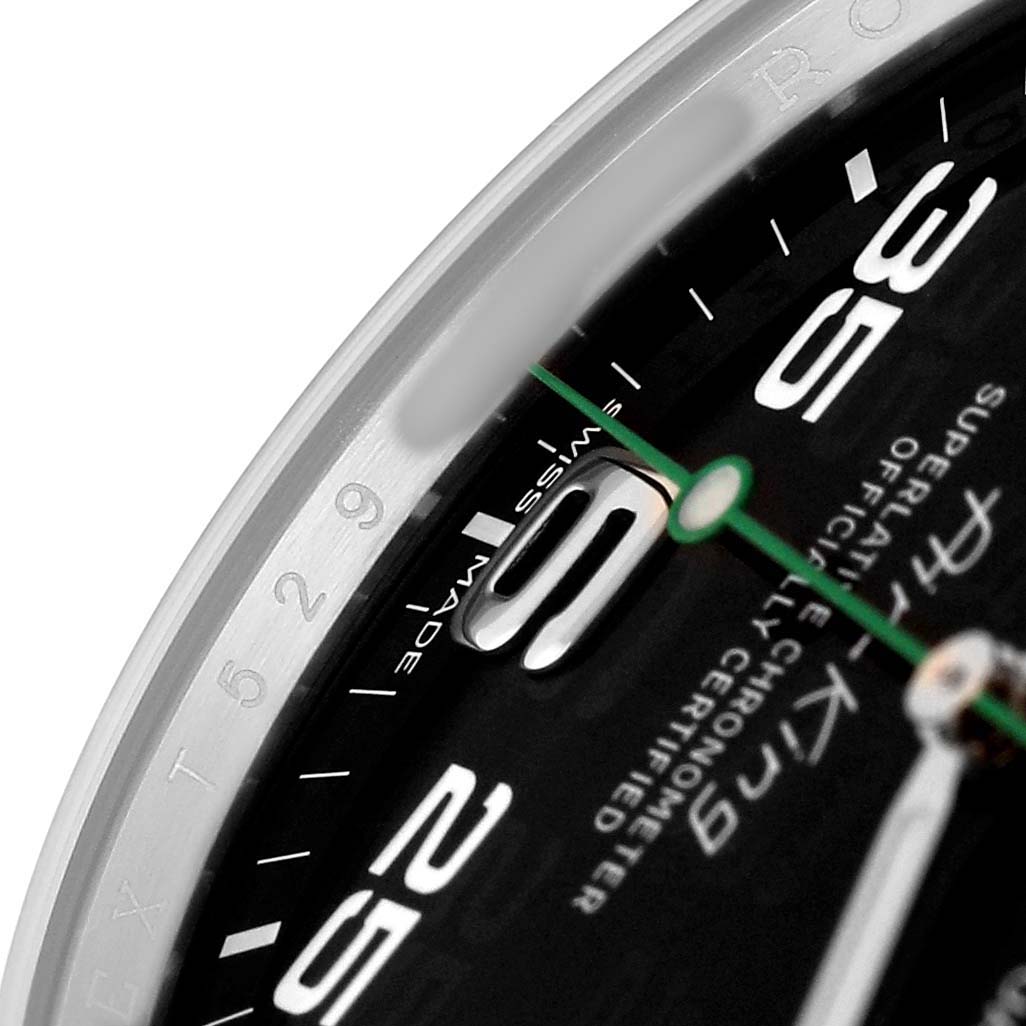 The image shows a close-up of the dial and bezel of the Rolex Air-King 116900 Men's Stainless Steel Black Dial, highlighting numerals and text.