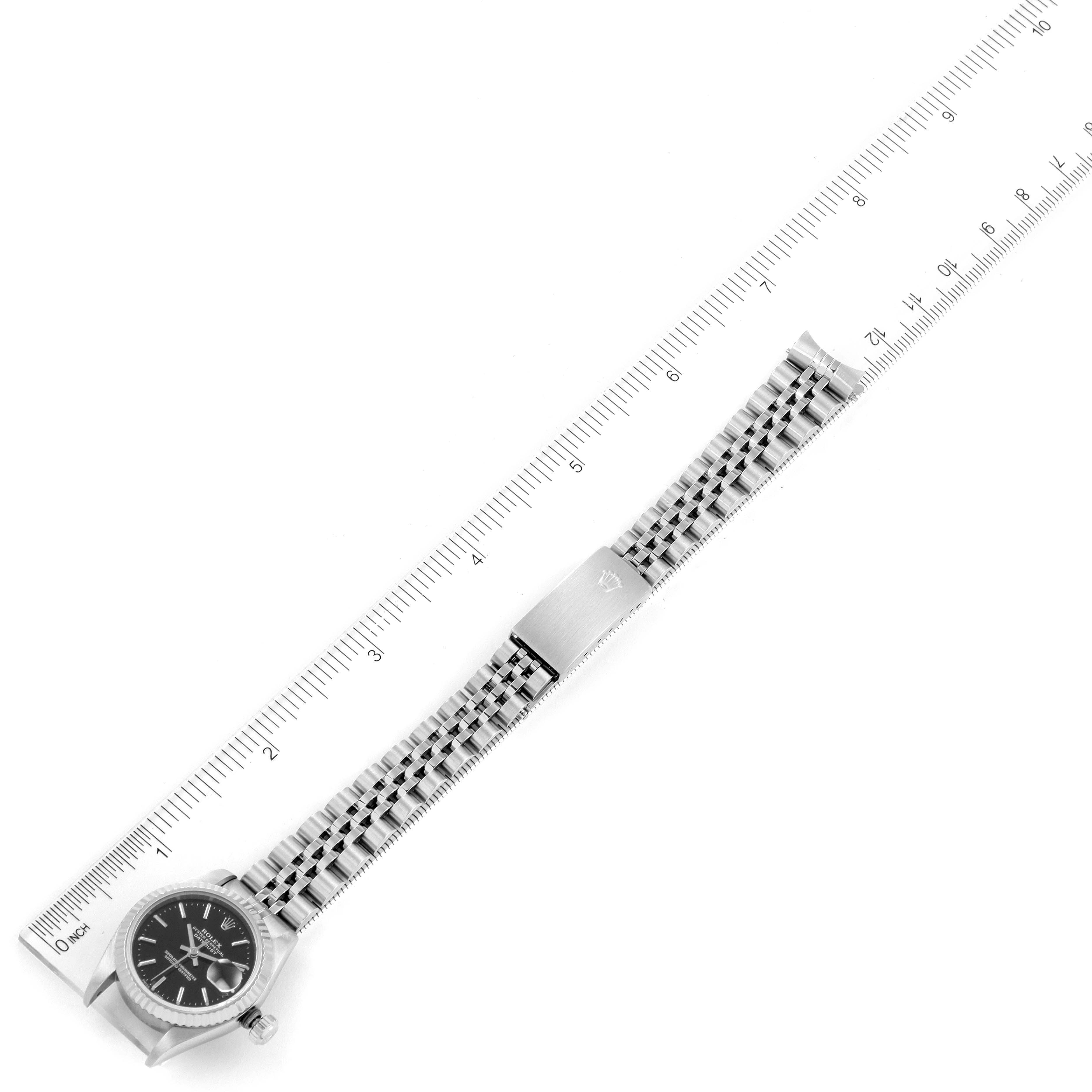 The image shows a top-down angle of a Datejust model Rolex watch alongside a ruler.