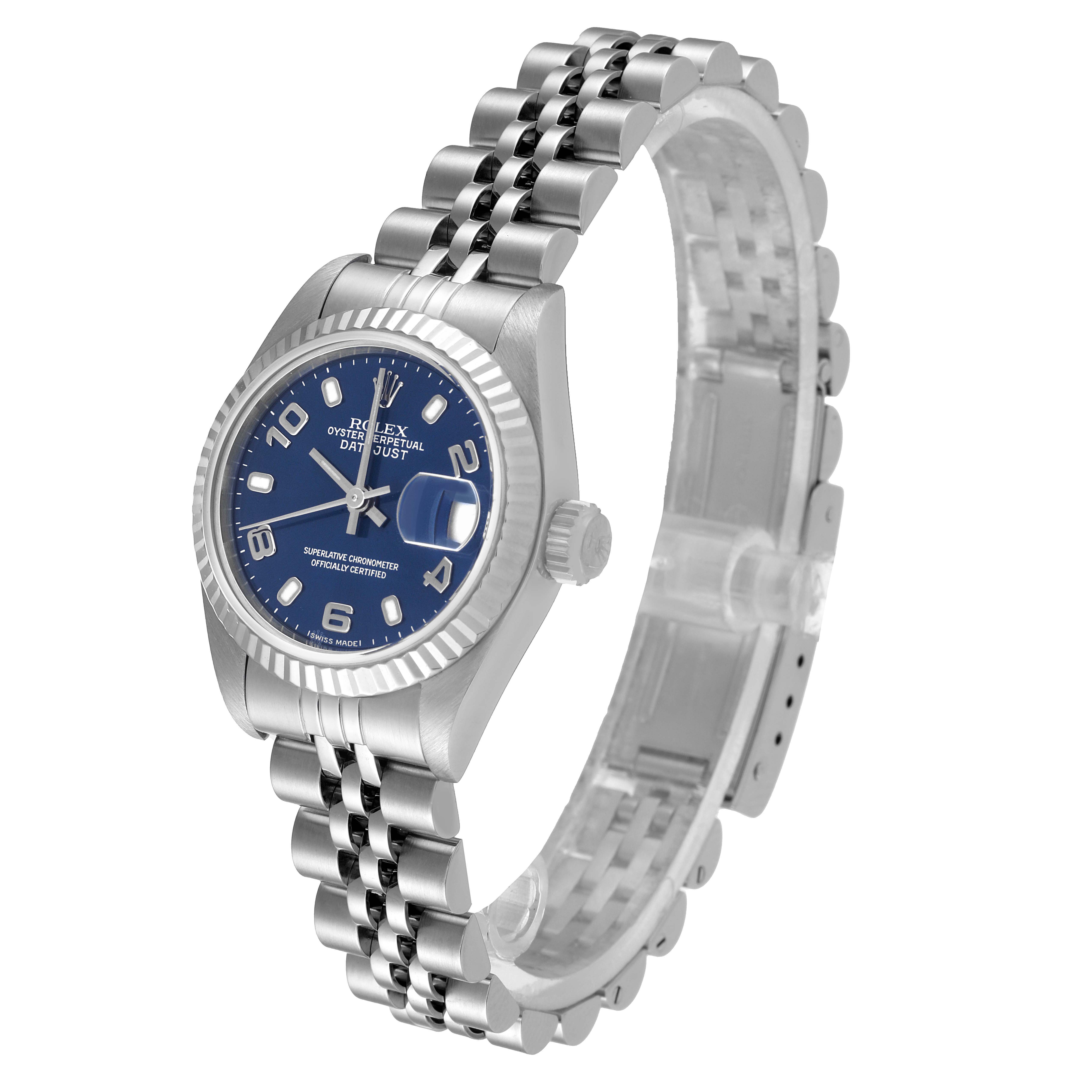 This Rolex Datejust 79174 Women
s Stainless Steel Blue Dial 79174 Women
s Stainless Steel Blue Dial watch is shown at a slight front-side angle, displaying its blue dial, fluted bezel, and Jubilee bracelet.
