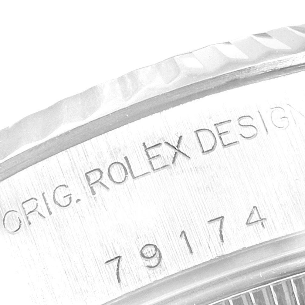 This close-up image shows the engraved serial number and "ORIG. ROLEX DESIGN" text on the side of the Rolex Datejust 79174 Women
s Stainless Steel Pink Dial 79174 Women
s Stainless Steel Pink Dial watch case.