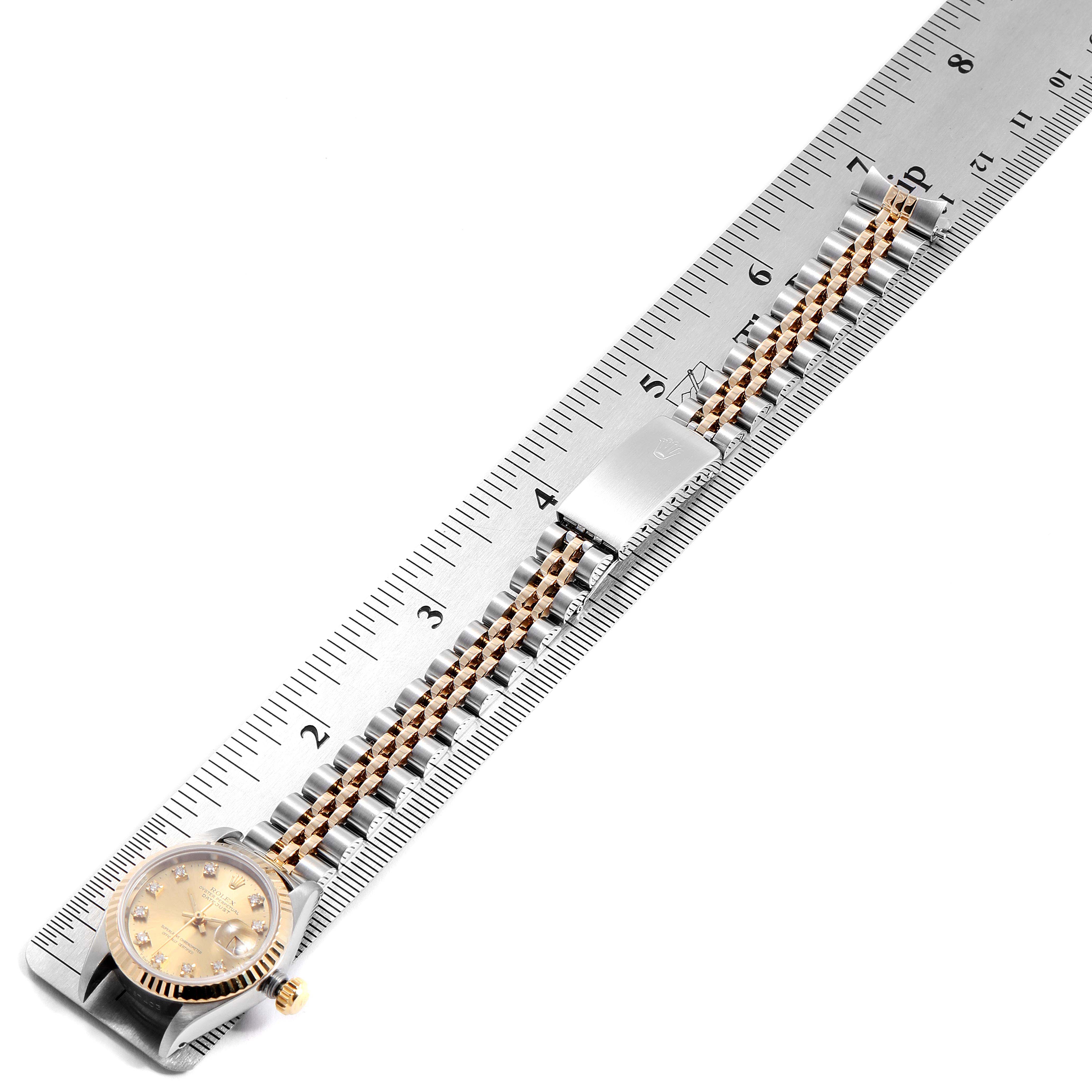 The Rolex Datejust 69173 Women
s Steel and Gold (two tone) Champagne Dial 69173 Women
s Steel and Gold (two tone) Champagne Dial watch is shown from a top-down angle, with the face and bracelet measured against a ruler.