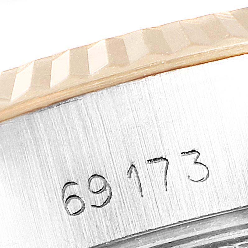 This is a close-up image of the bezel and case of a Rolex Datejust 69173 Women
s Steel and Gold (two tone) Champagne Dial 69173 Women
s Steel and Gold (two tone) Champagne Dial watch, focusing on the engraved serial number 69173.