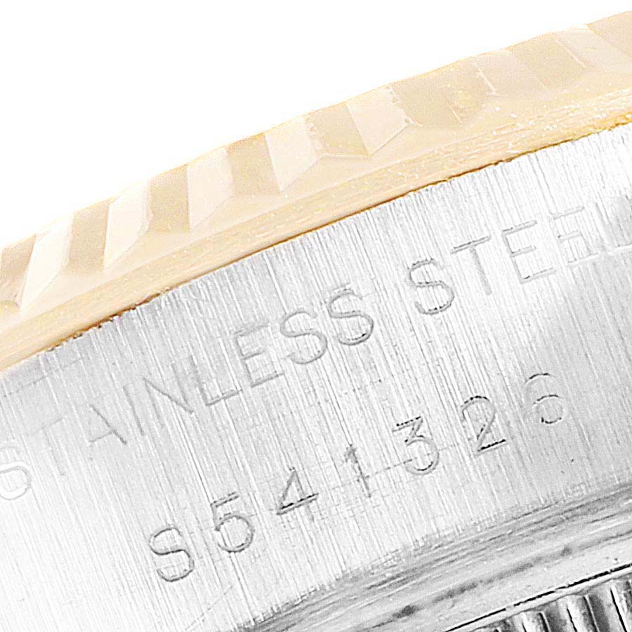 This close-up image shows part of the fluted bezel and engraved stainless steel back of a Rolex Datejust 69173 Women
s Steel and Gold (two tone) Champagne Dial 69173 Women
s Steel and Gold (two tone) Champagne Dial watch.