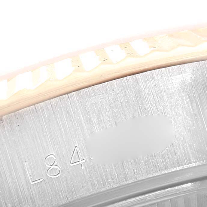 This image shows a close-up of the serial number area on the bezel and inner case of a Rolex Datejust 69173 Women's Steel and Gold (two tone) Red Dial 69173 Women's Steel and Gold (two tone) Red Dial watch.
