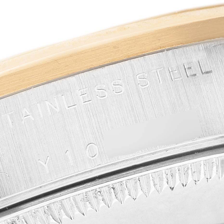 The image shows a close-up of the bezel and case edge of a Rolex Mid-Size 78243 Women's Steel and Gold (two tone) White Dial watch, highlighting the stainless steel engraving.